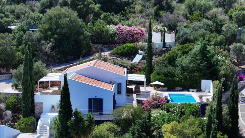 Aerial view of the second villa with gabled terracotta roofs, pergola terraces and private pool among cypress and oleander