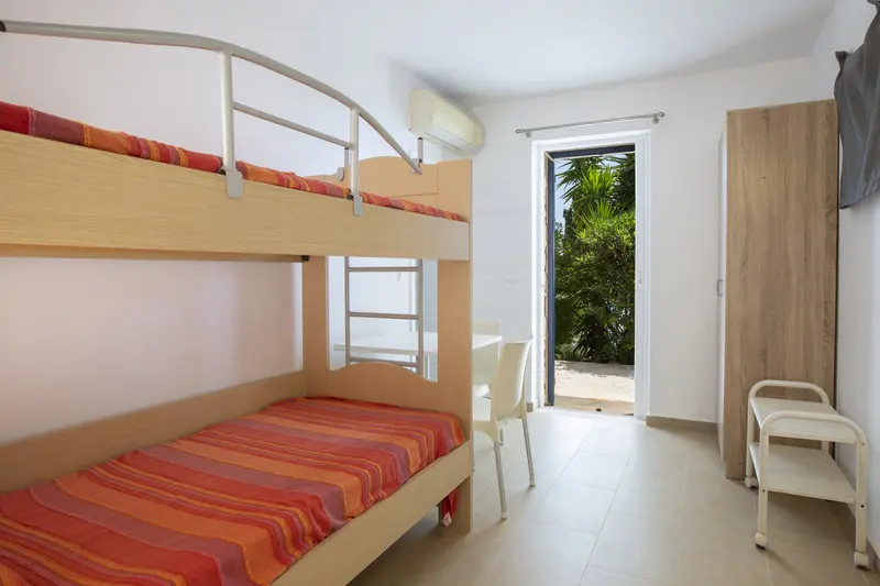 Bunk room with built in timber beds and a small window to the garden